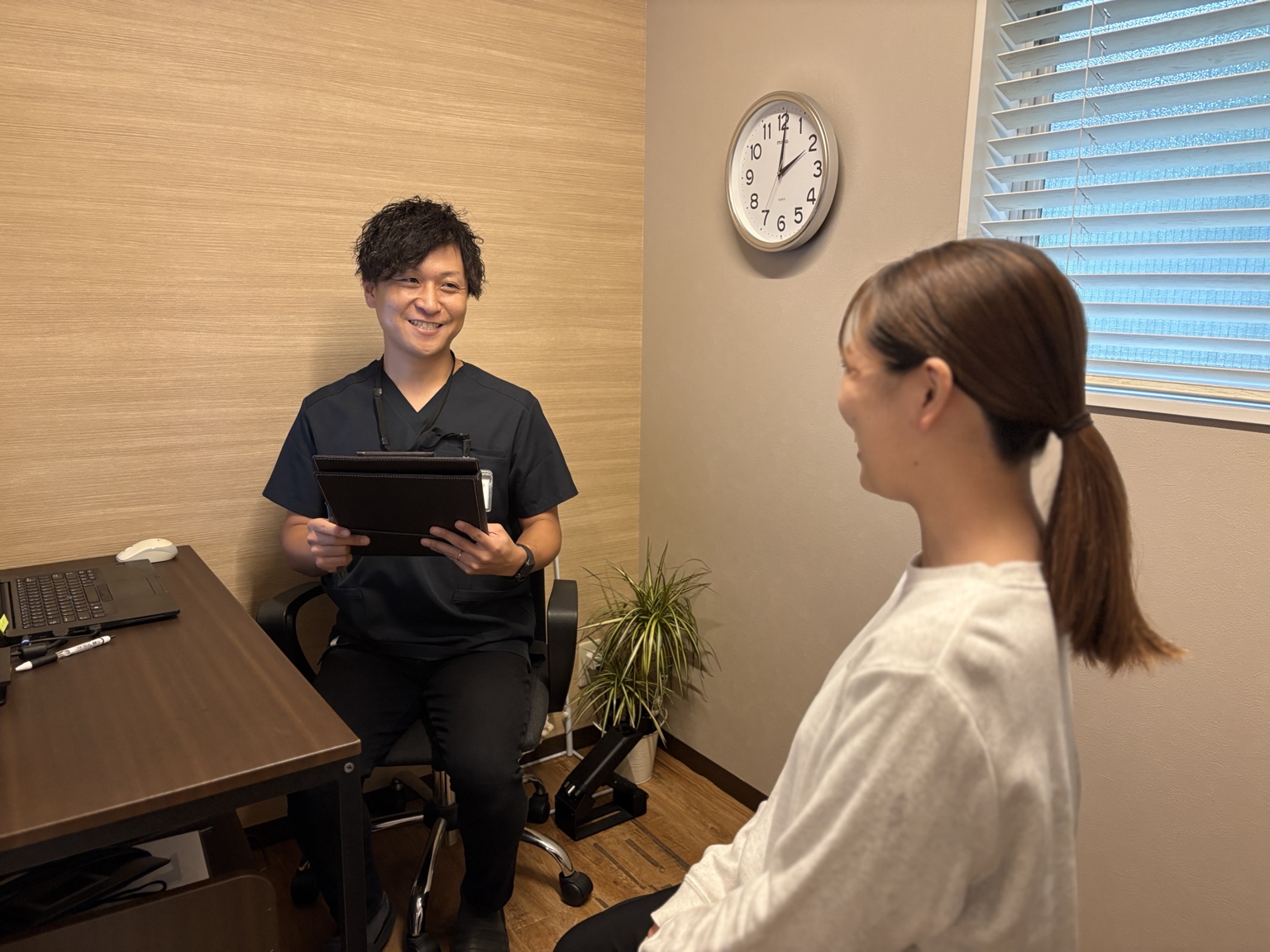 患者様の事故状況や身体の悩みを伺うスタッフ